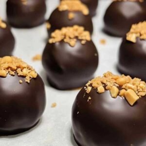 Boules de Beurre de Cacahuète à la Reese’s 7 Boules de beurre de cacahuète enrobées de chocolat sur un plateau de service