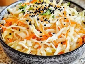 Salade de chou blanc à la japonaise servie dans un bol avec graines de sésame