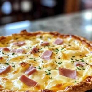 Quiche au Jambon de Poulet et Raclette 7 Part de quiche au jambon de poulet et raclette servie dans une assiette