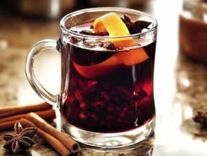 Service du vin chaud épicé avec une louche dans des verres décorés
