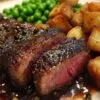 Assiette complète avec bifteck sauce au poivre, pommes rissolées et petits pois