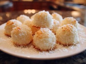 Boules coco meringuées sans gluten dorées sur plaque de cuisson