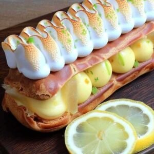 Éclairs Meringués au Citron 3 Éclairs meringués au citron sur présentoir à pâtisserie