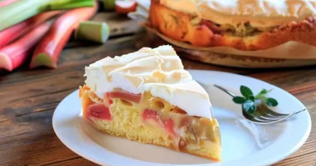 Tarte à la Rhubarbe Meringuée 1 Part de tarte à la rhubarbe meringuée servie dans une assiette