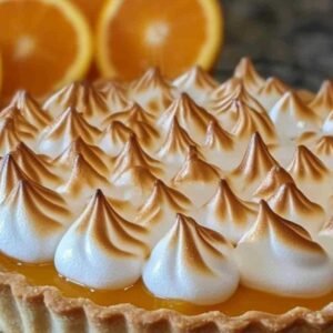 Tarte aux Oranges Meringuée : Un Dessert Ensoleillé et Rafraîchissant 3 Part de tarte aux oranges meringuée servie sur assiette blanche