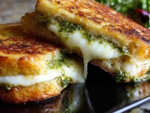 Ingrédients pour la recette du croque-monsieur chèvre pesto : pain de mie, fromage de chèvre, pot de pesto, fromage râpé et beurre.