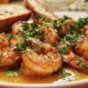 Action de flamber des gambas dans une poêle noire sur une gazinière, avec des flammes vives s'élevant du Cognac.