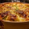 Gratin de courgettes léger et doré dans un plat en céramique blanc, avec du fromage bouillonnant.