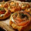 Le rouleau de pâte feuilletée garni de fromage frais, de saumon fumé et d'aneth, prêt à être découpé en tranches.