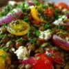 Salade de lentilles aux tomates cerises et feta dans un saladier blanc