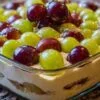 Composition d'ingrédients pour la recette du tiramisu au raisin : raisins verts et violets, pot de mascarpone, œufs et biscuits.