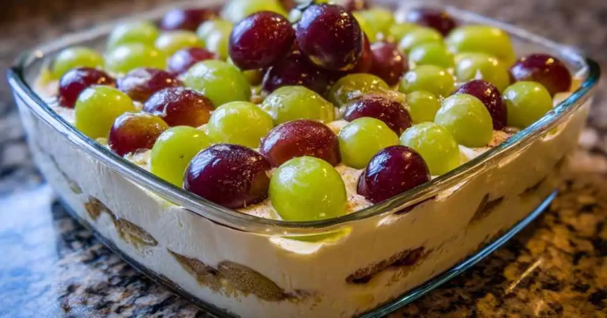 Composition d'ingrédients pour la recette du tiramisu au raisin : raisins verts et violets, pot de mascarpone, œufs et biscuits.