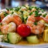 Salade de crevettes servie dans des verrines individuelles avec ciboulette