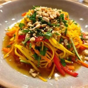 Salade de Mangue Thaï 3 Vinaigrette asiatique versée sur salade de mangue dans saladier