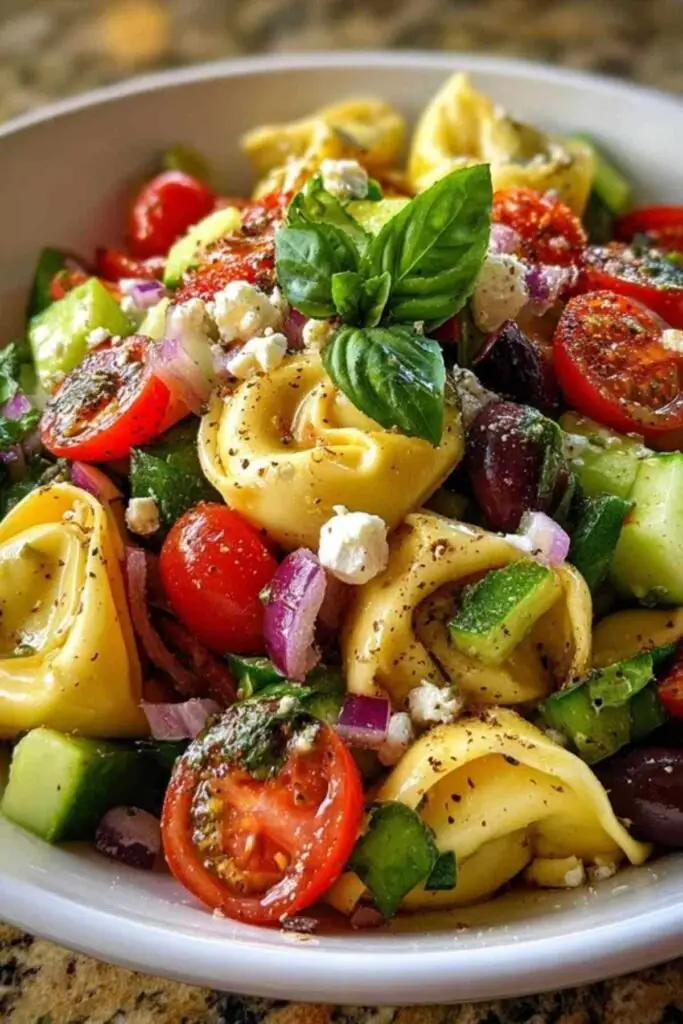 Ingrédients pour salade tortellini grecque disposés sur plan de travail