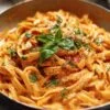 Pâtes crémeuses à la tomate cuites dans une casserole avec basilic