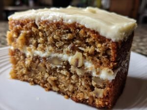 Gros plan d'une tranche de barres à la banane avec glaçage crémeux et morceaux de noix.