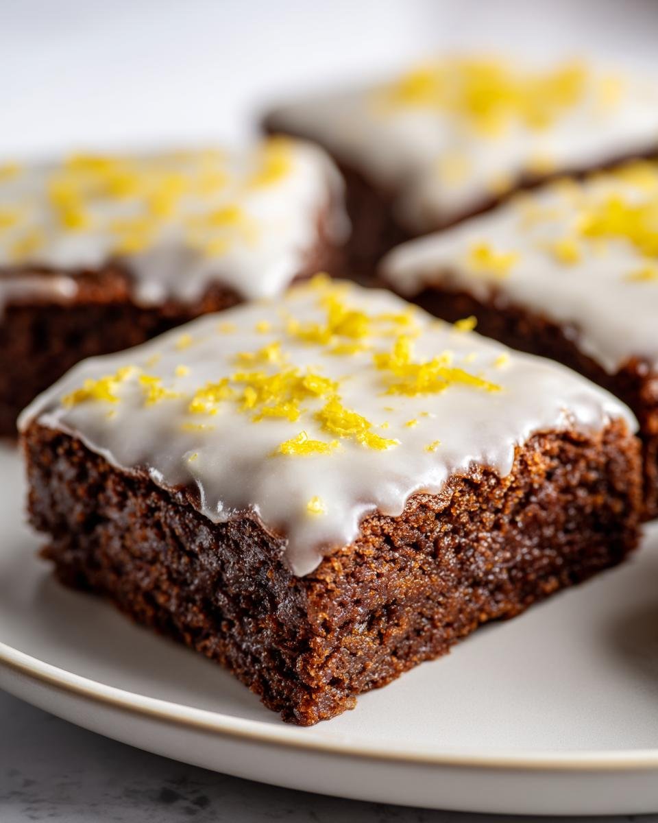 Brownies au Citron: 40 min, délice garanti 2 Gros plan sur un brownie au citron moelleux, recouvert d'un glaçage blanc et de zestes de citron.