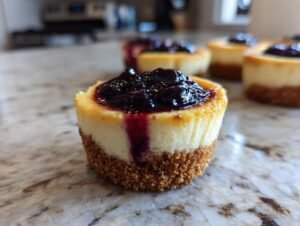 Gros plan sur un mini cheesecake aux myrtilles et citron, garni de myrtilles et d'un coulis.