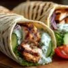 Wraps de poulet tzatziki avec salade de concombre et tomate sur assiette