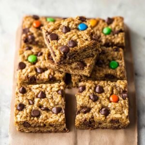 Gros plan sur des barres gourmandes aux pépites de chocolat et flocons d'avoine, garnies de bonbons colorés.