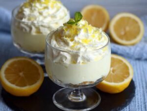 Deux coupes de Crème Mascarpone au Citron garnies de crème fouettée, de zeste de citron et de menthe.