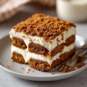 Gros plan d'une part de Tiramisu Biscoff Spéculoos végétalien, garnie de miettes de Spéculoos.