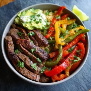 Bol de Fajitas Steak Haute Protéine avec riz, poivrons colorés, avocat et coriandre fraîche.